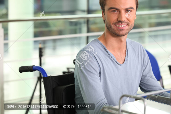 坐在辦公桌上的輪椅使用者
