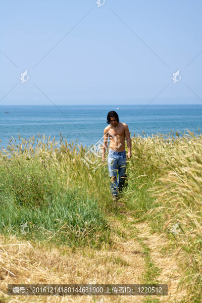 海灘上行走的肌肉男模特