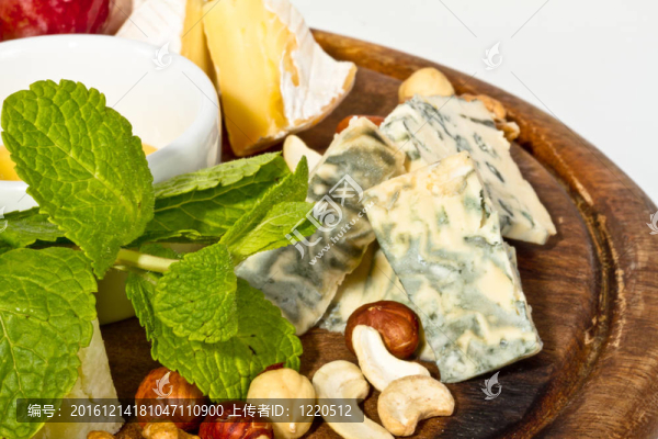 各種帶蜂蜜的奶酪；盤子上的堅果和葡萄；在白色上分離
