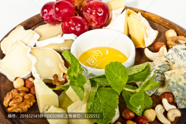 各種帶蜂蜜的奶酪；盤子上的堅(jiān)果和葡萄；在白色上分離