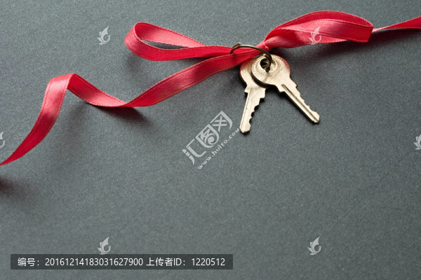 灰色背景上帶絲帶的鑰匙