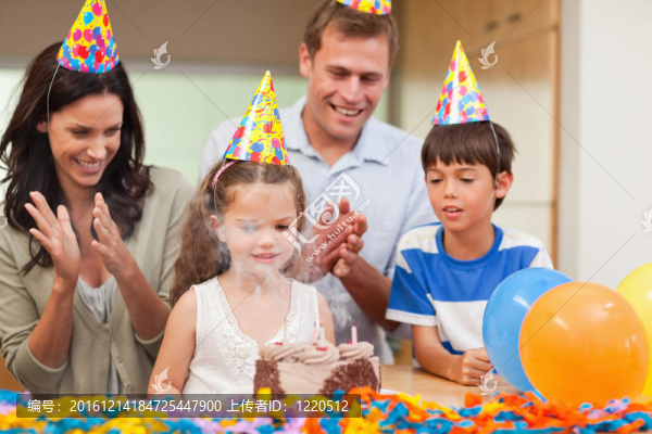 父母為她的小女兒剛剛吹滅了生日蛋糕上的蠟燭