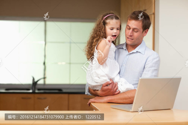 女孩對她父親的筆記本電腦很感興趣