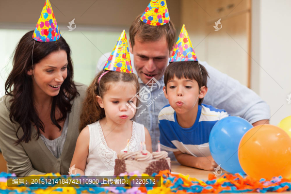 小男孩幫他妹妹吹滅生日蛋糕上的蠟燭