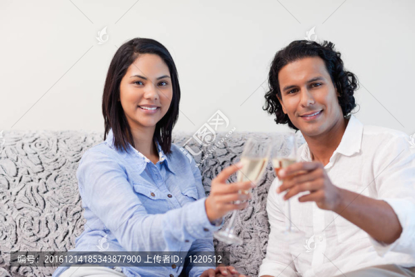 夫婦在沙發(fā)上用起泡酒慶祝