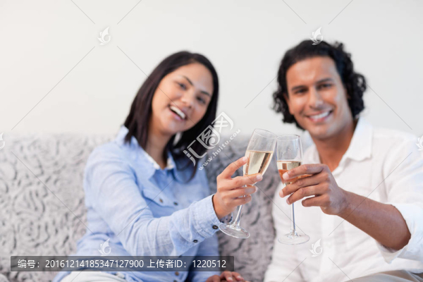 夫婦在沙發(fā)上用起泡酒慶祝