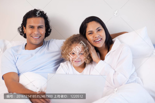 家人坐在床上用筆記本