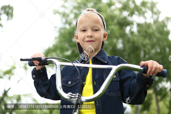 在綠色公園騎自行車的男孩