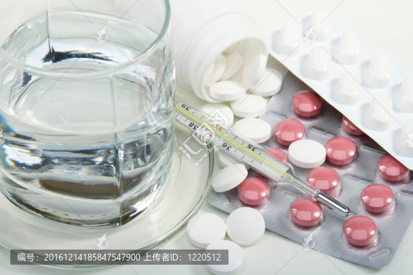 不同藥丸；玻璃水和醫(yī)用溫度計(jì)。