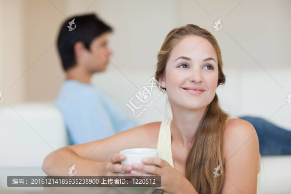 女人在未婚夫坐在沙發(fā)上喝咖啡