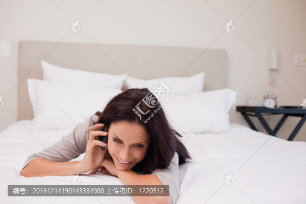 在床上快樂地打電話的女人