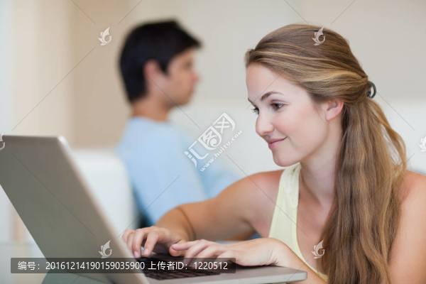 當未婚夫坐在沙發(fā)上時，女人用筆記本電腦
