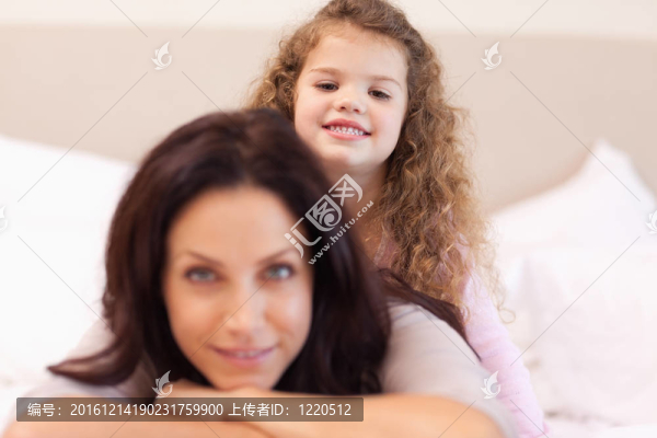 微笑的女孩坐在媽媽的背上
