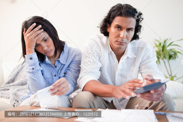 沮喪的夫婦在客廳檢查賬單