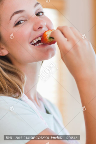 一個年輕女子正在吃草莓