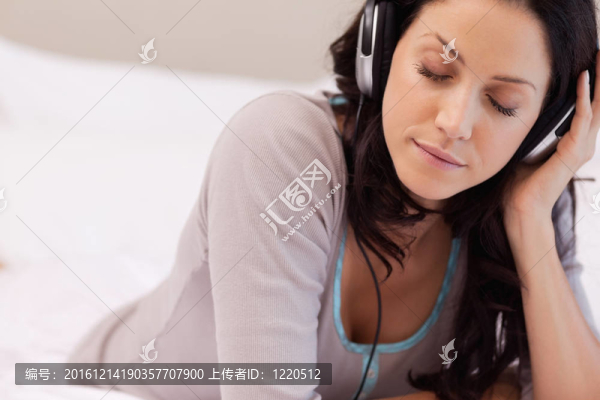 在臥室里享受音樂的女人