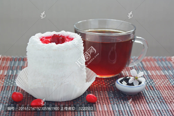 一杯茶，奶油蛋糕，櫻桃和一罐茶葉，還有竹子桌布上的櫻花