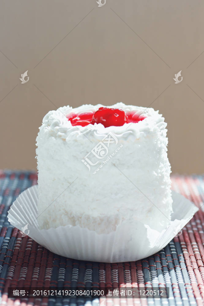 奶油蛋糕與櫻桃在竹桌布仍然生活