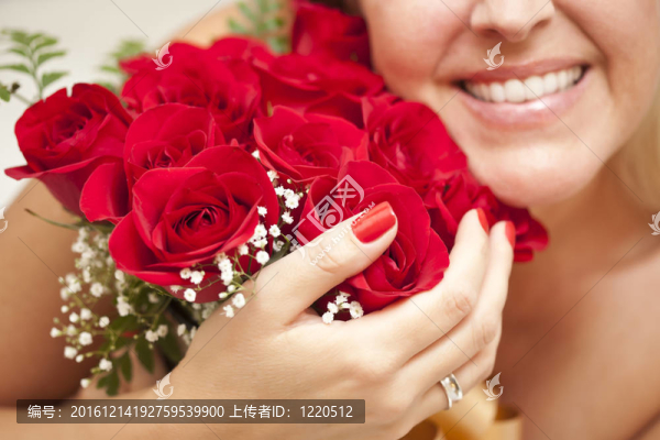 微笑的女人拿著一串紅玫瑰