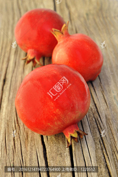 在木板上的三鮮紅色pomegrantes