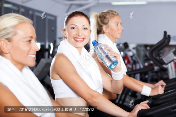 年輕女子在健身房喝水