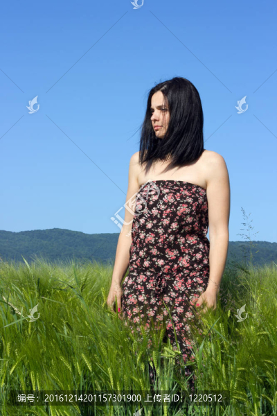 站在綠色麥田里的年輕女子