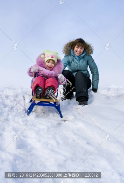 母親和女兒坐雪橇