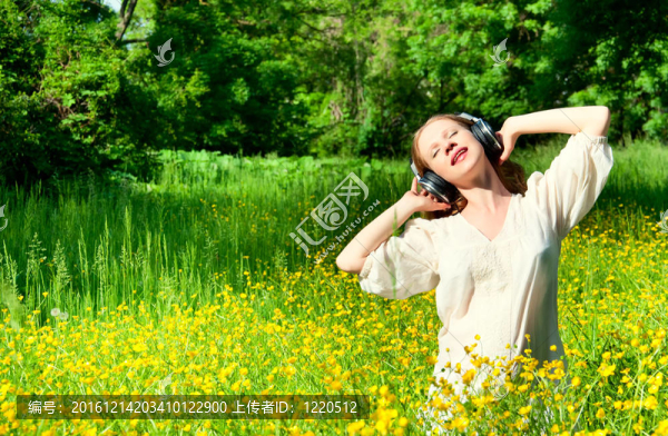 美麗的女孩在耳機(jī)享受音樂在一個領(lǐng)域的佛羅里達(dá)州