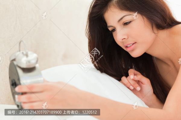 手里拿著鐘，看著時(shí)間的女人