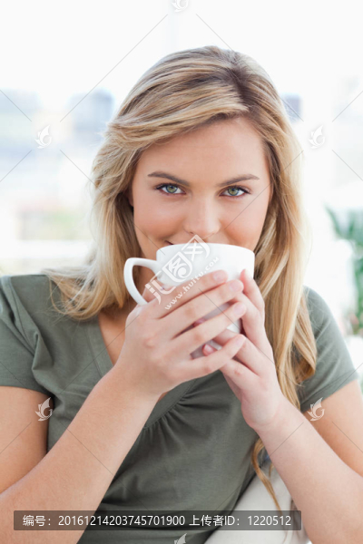 一個特寫鏡頭的女人期待著，因為她持有一個杯子在她的嘴前面。
