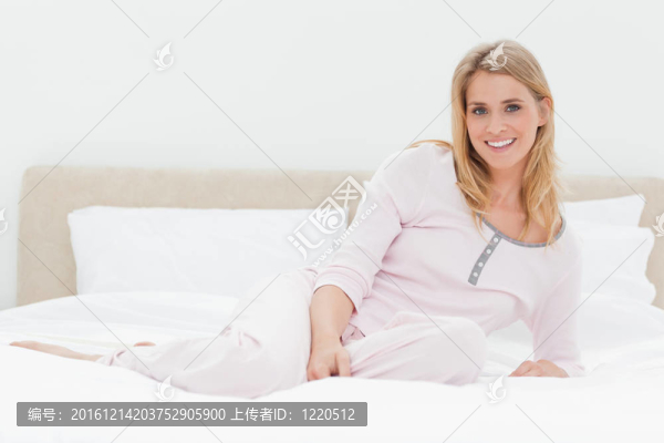 女人躺在床上；微微地向后靠著，微笑著