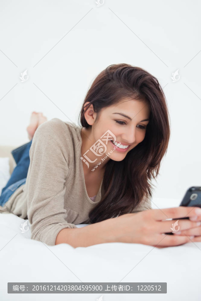 特寫；女人用手機在床上微笑
