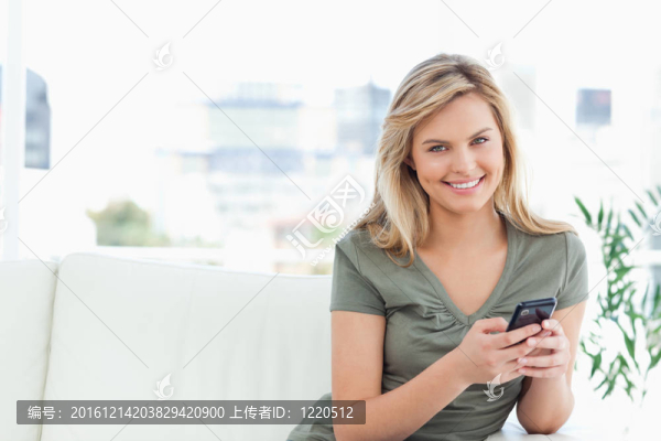 女人看著前面和微笑，因為她用她的電話