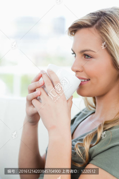 特寫；女人側(cè)身看；手里拿著杯子，面帶微笑