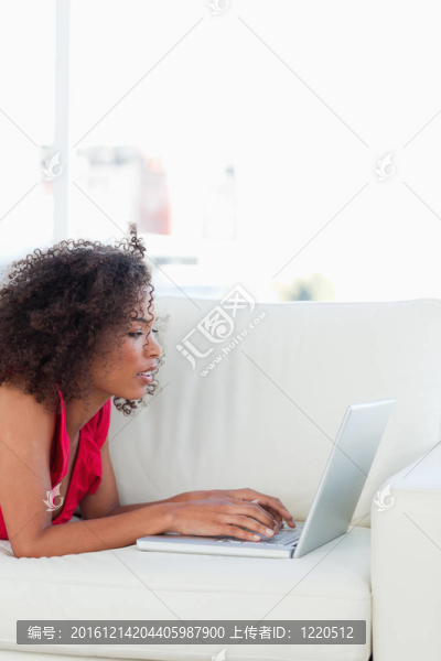 沙發(fā)上的女人；看著和使用她的筆記本電腦