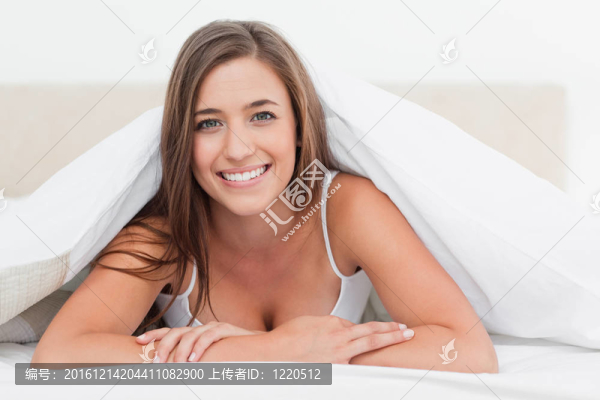 躺在床尾的女人；微笑著向前看