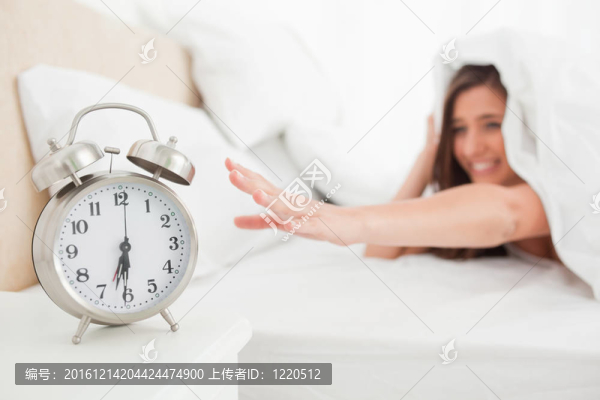 被子下的女人伸手去拿鐘