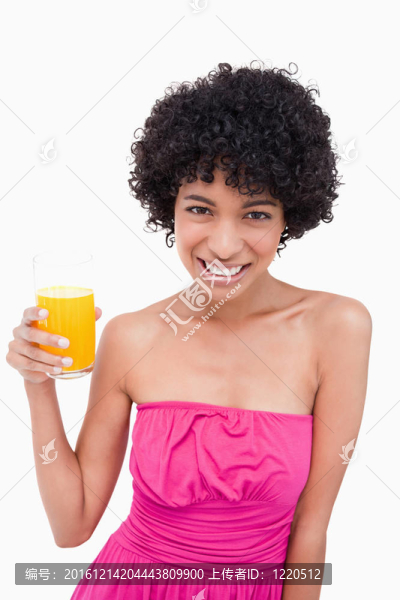 年輕女子微笑著拿著一杯橙汁