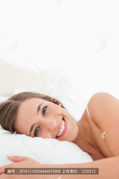 特寫；女人在床上燦爛地微笑