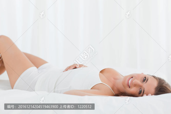女人躺在床上，背上；微笑著向前看