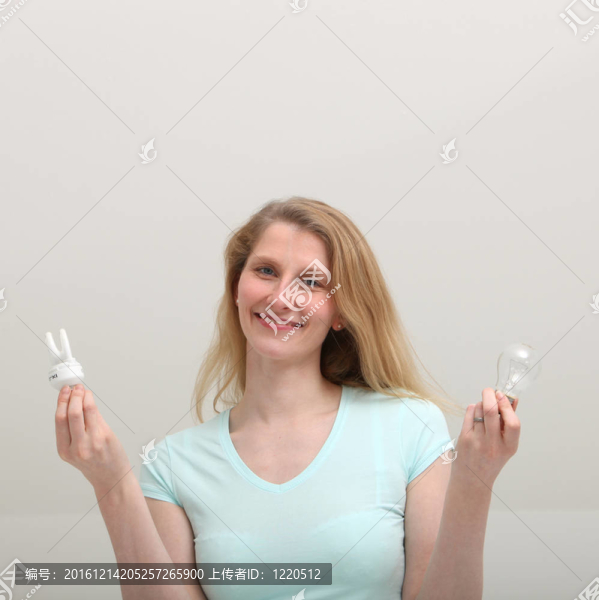 快樂(lè)的女人拿著不同的燈泡