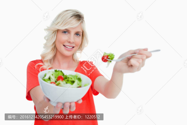 年輕的金發(fā)女子拿著一碗新鮮沙拉