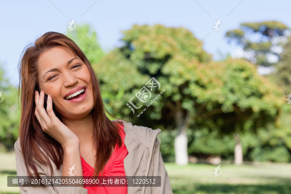 一位年輕女子在明亮的公園里愉快地笑著