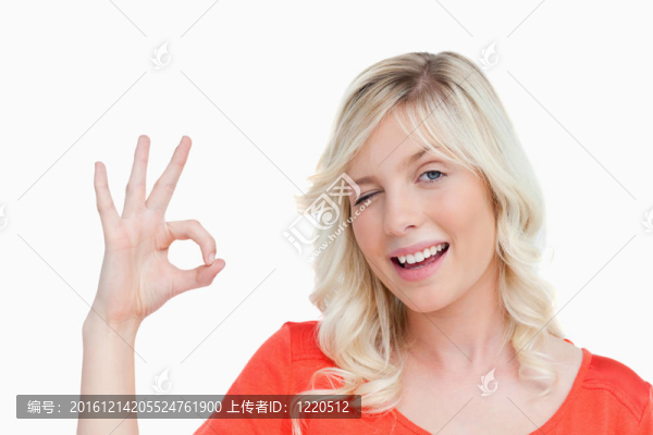 年輕的金發(fā)女子顯示OK標(biāo)志和眨眼