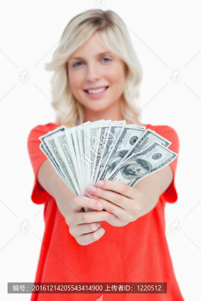一個由微笑迷人的女人持有的鈔票的扇子