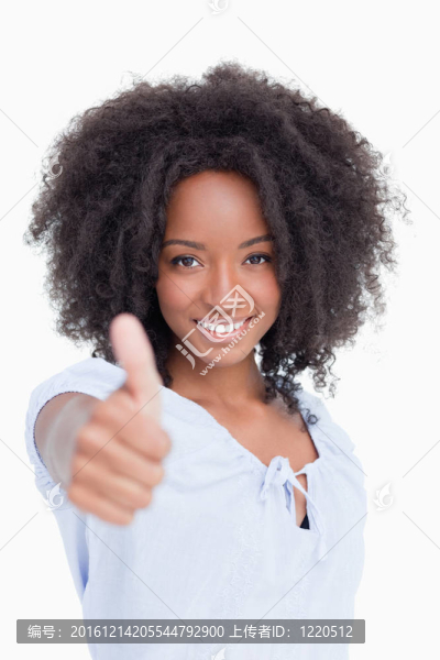 女人微笑著站著，豎起大拇指，滿意