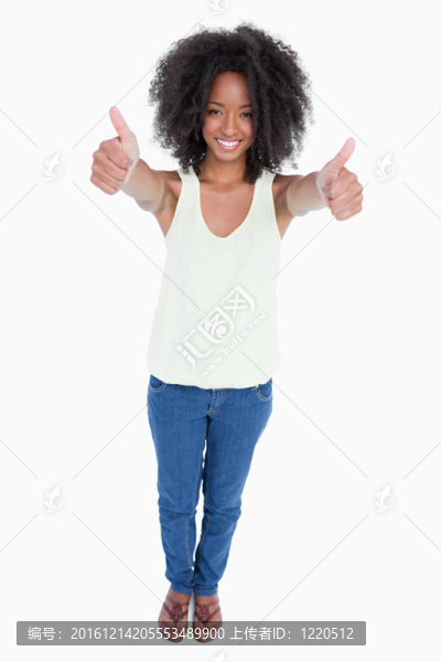 年輕的放松的女人站著豎起大拇指
