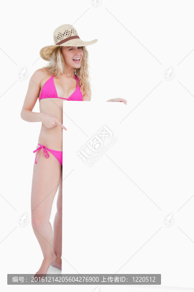 微笑的少年眨著眼睛，手里拿著一張空白的海報