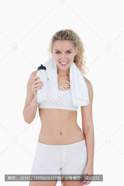 年輕的微笑女人站在她的脖子上用毛巾