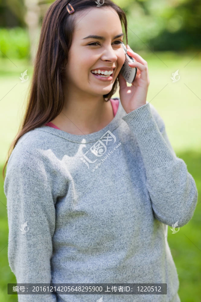 小女孩在公園里打電話邊笑